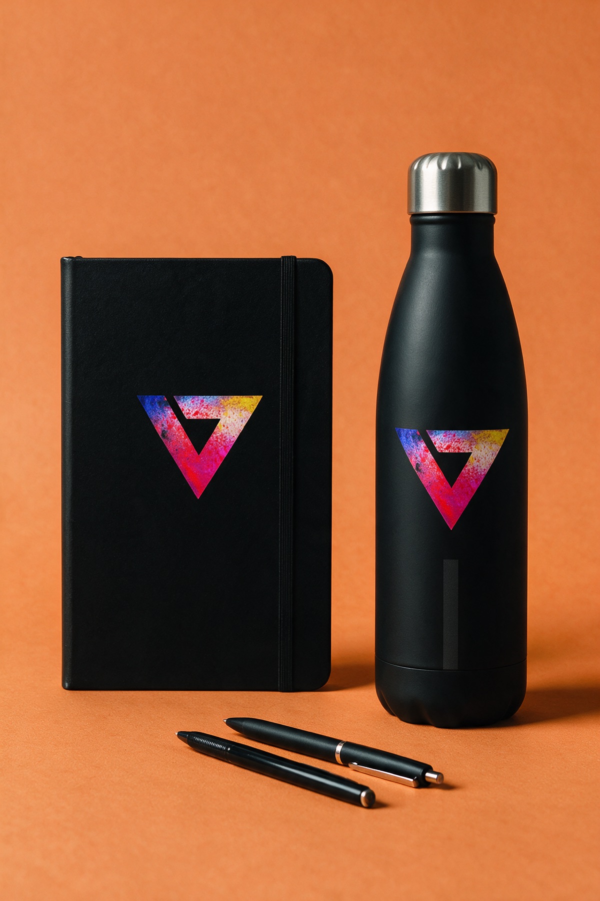 Caderno, canetas e garrafa
