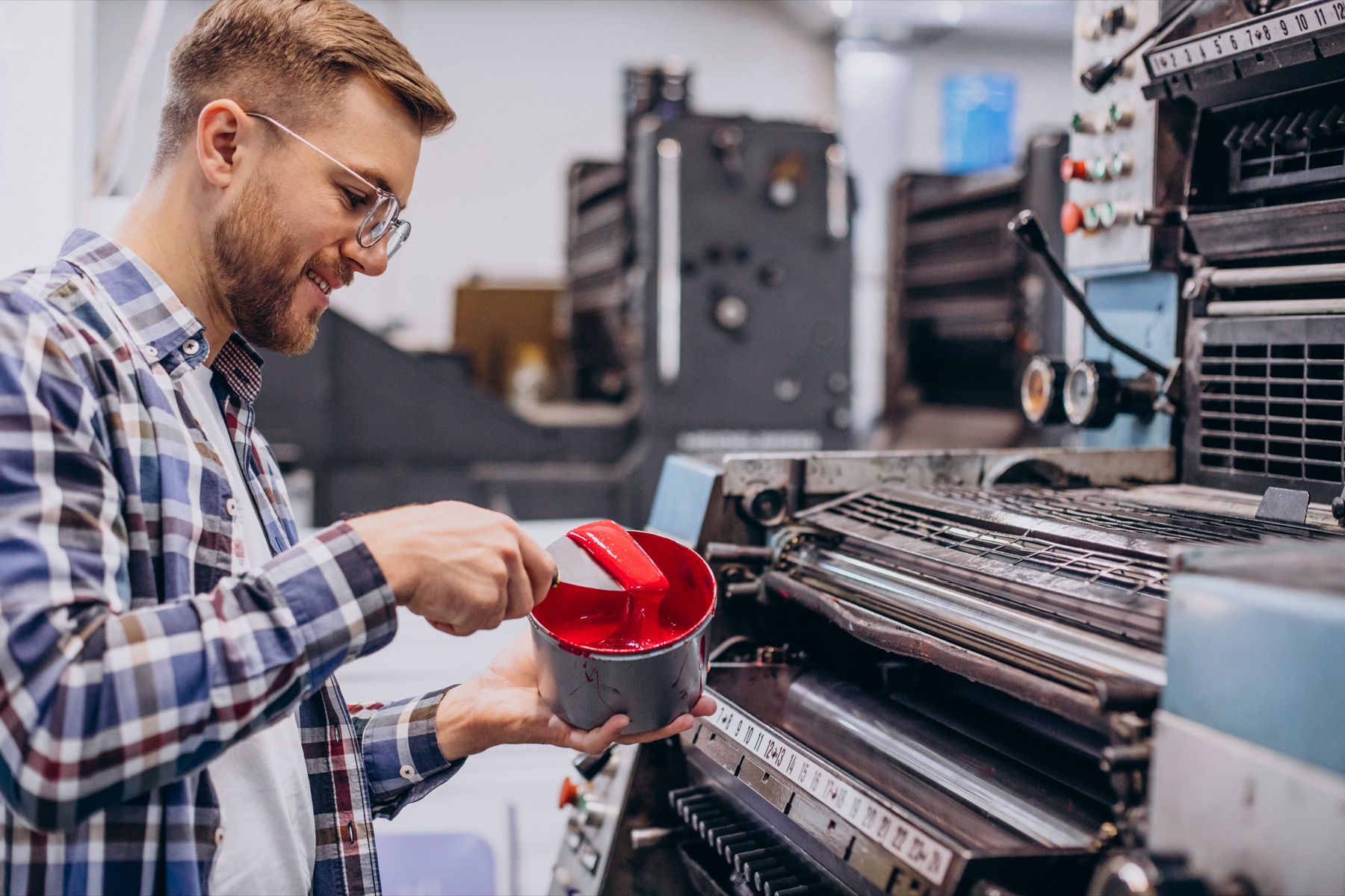 Operador a preparar tinta numa máquina de impressão